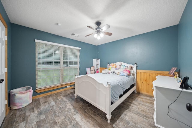 309 County Road 3665 E, Splendora, TX 77372 - bedroom with a textured ceiling, wood finished floors, and ceiling fan