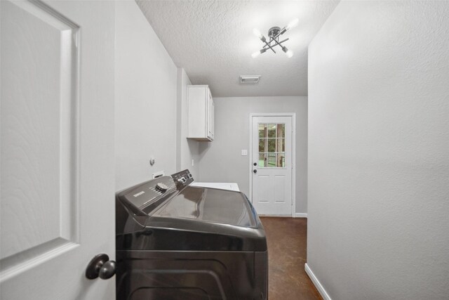 309 County Road 3665 E, Splendora, TX 77372 - laundry room featuring washer and dryer, cabinet space, a textured ceiling, dark carpet, and baseboards