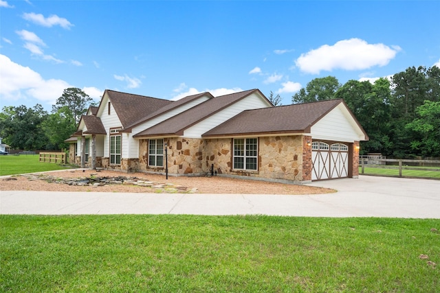 309 County Road 3665 E, Splendora, TX 77372 - view of front of property featuring stone siding, an attached garage, concrete driveway, and a shingled roof