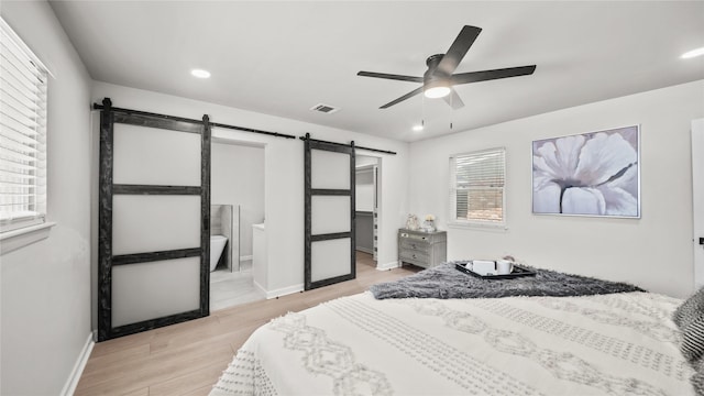 9210 Linkmeadow Ln, Houston, TX 77025 - bedroom featuring a barn door, light wood finished floors, baseboards, recessed lighting, and a ceiling fan
