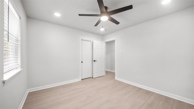 9210 Linkmeadow Ln, Houston, TX 77025 - unfurnished bedroom with light wood-type flooring, multiple windows, baseboards, a closet, and recessed lighting