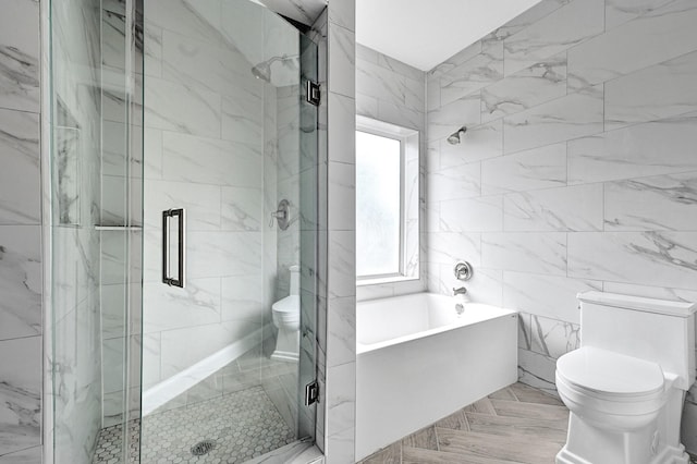 full bath featuring toilet, a stall shower, a garden tub, and tile walls