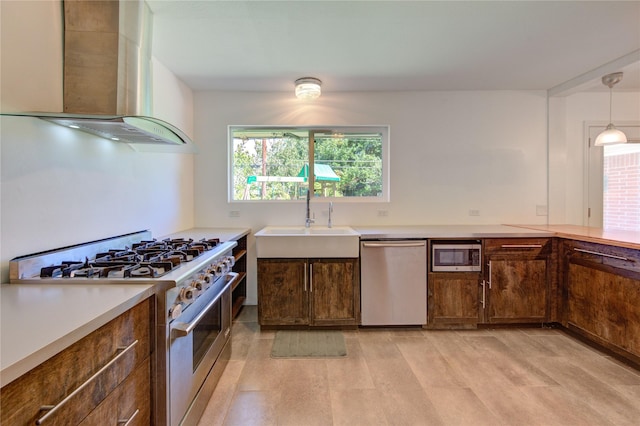 4538 Warm Springs Rd, Houston, TX 77035 - kitchen with stainless steel appliances, wall chimney range hood, a sink, light countertops, and pendant lighting