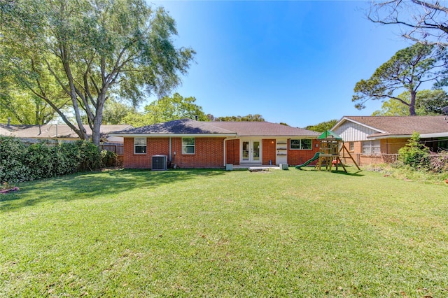 4538 Warm Springs Rd, Houston, TX 77035 - back of house featuring a playground, central air condition unit, french doors, brick siding, and roof with shingles