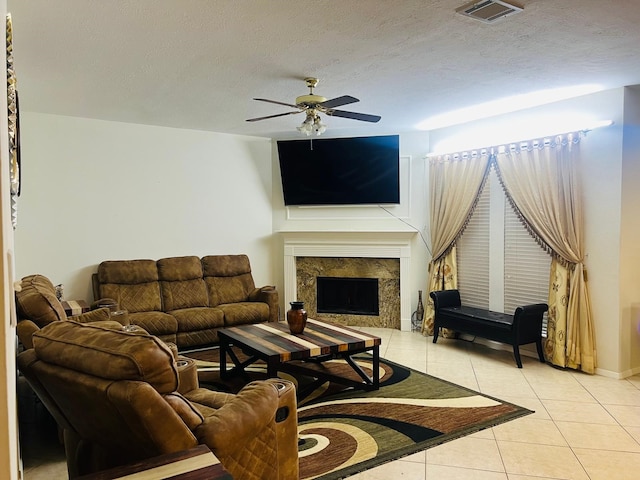 110 Chandler Ct, Sugar Land, TX 77479 - living room featuring light tile patterned flooring, a ceiling fan, a high end fireplace, and a textured ceiling