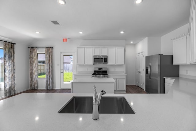 9639 Sterling Arbor Dr, Baytown, TX 77521 - kitchen featuring appliances with stainless steel finishes, a sink, white cabinetry, recessed lighting, and a center island