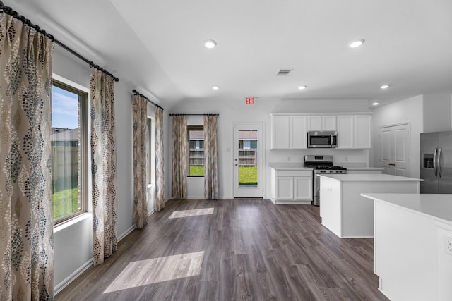 9639 Sterling Arbor Dr, Baytown, TX 77521 - kitchen featuring stainless steel appliances, a kitchen island, light countertops, white cabinetry, and dark wood finished floors