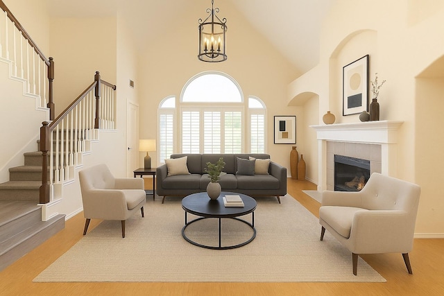living area with high vaulted ceiling, stairway, wood finished floors, and a chandelier