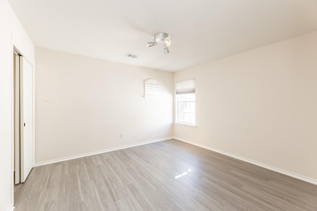unfurnished room with wood finished floors and baseboards