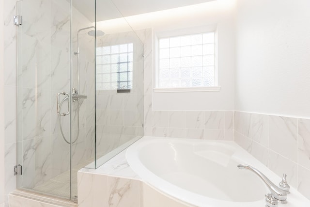 bathroom with a marble finish shower and a bath
