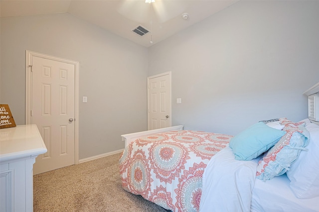 bedroom featuring light colored carpet, lofted ceiling, and baseboards