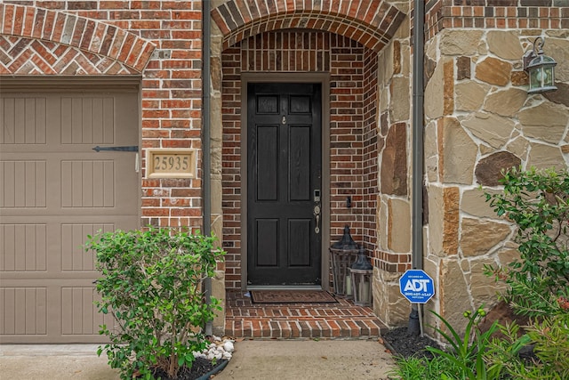 property entrance featuring brick siding and an attached garage