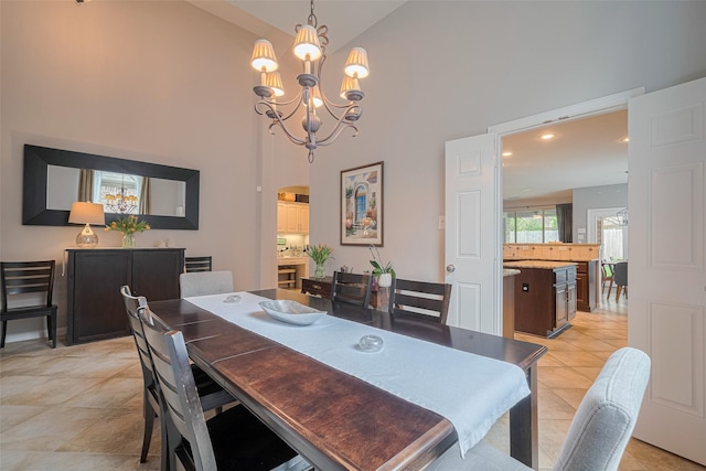 dining area featuring a chandelier, a towering ceiling, light tile patterned flooring, and recessed lighting