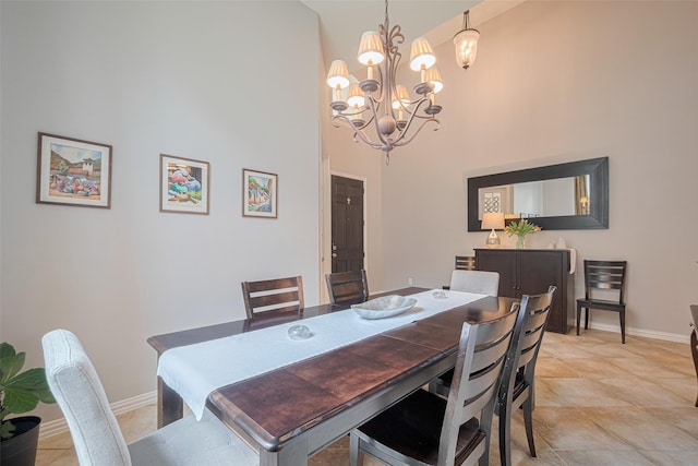 dining area with a high ceiling, baseboards, and a chandelier