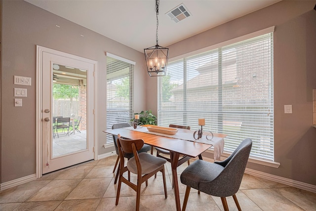 dining area with baseboards, light tile patterned floors, and a chandelier
