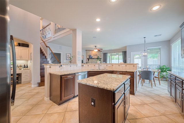 kitchen with a center island, stainless steel appliances, a sink, recessed lighting, and light tile patterned floors