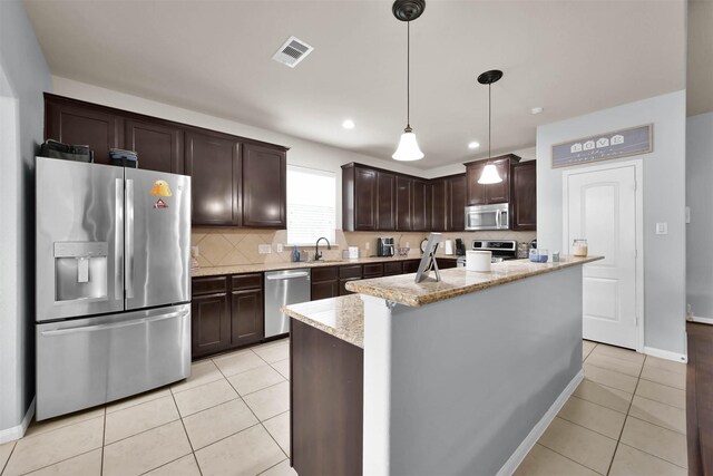kitchen with stainless steel appliances, dark brown cabinetry, light tile patterned floors, decorative backsplash, and recessed lighting