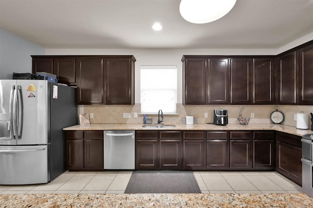 kitchen featuring stainless steel appliances, a sink, light tile patterned floors, dark brown cabinetry, and recessed lighting