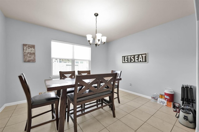 dining area featuring a chandelier, light tile patterned flooring, and baseboards
