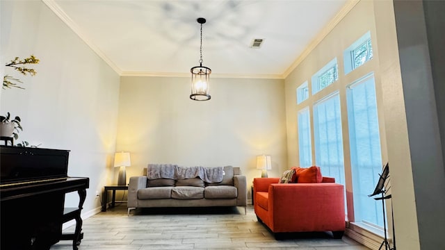 living room featuring ornamental molding, light wood-style flooring, and baseboards