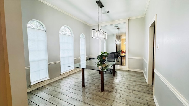 dining room featuring wood finished floors, crown molding, and baseboards