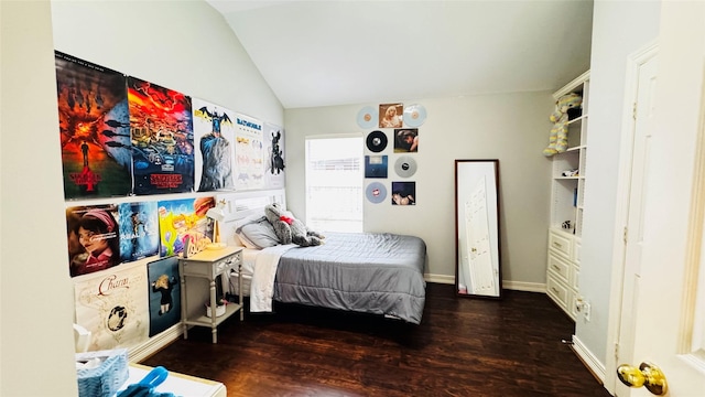 bedroom with vaulted ceiling, wood finished floors, and baseboards