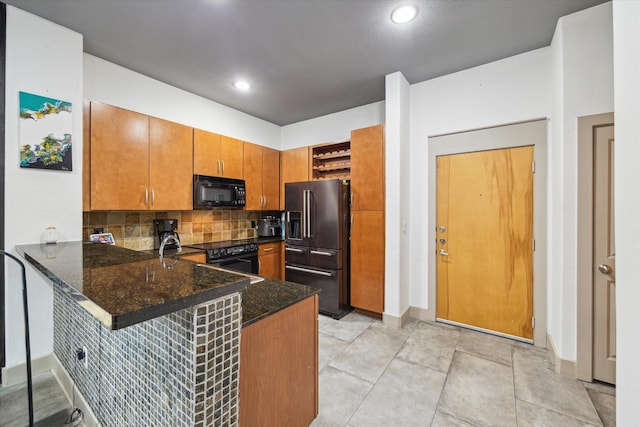 kitchen featuring black appliances, a peninsula, open shelves, brown cabinetry, and decorative backsplash