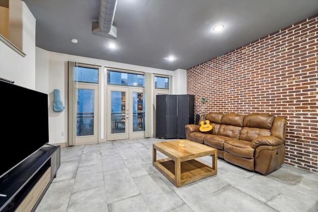 living room with brick wall, french doors, and recessed lighting