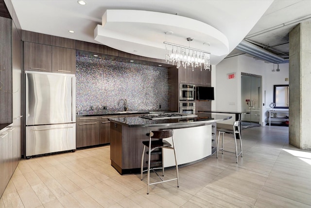 kitchen featuring freestanding refrigerator, dark countertops, a kitchen bar, tasteful backsplash, and modern cabinets