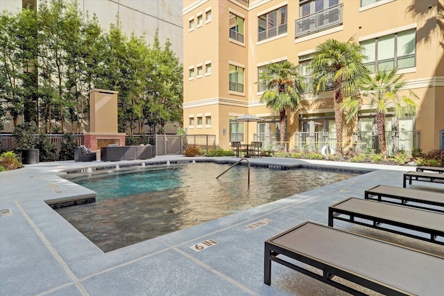 community pool featuring fence, a patio area, and an outdoor living space