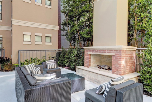 view of patio / terrace with an outdoor living space with a fireplace and fence