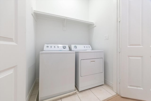 2813 Clinton Dr, Houston, TX 77020 - clothes washing area with washer and dryer, light tile patterned flooring, and baseboards