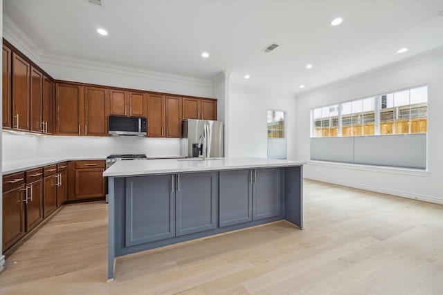 2813 Clinton Dr, Houston, TX 77020 - kitchen featuring stainless steel appliances, ornamental molding, a kitchen island, light wood-style floors, and light countertops