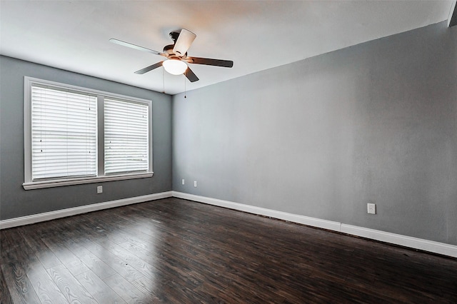 empty room featuring ceiling fan, dark wood-style flooring, and baseboards