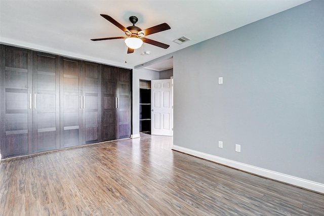 spare room featuring ceiling fan, wood finished floors, and baseboards
