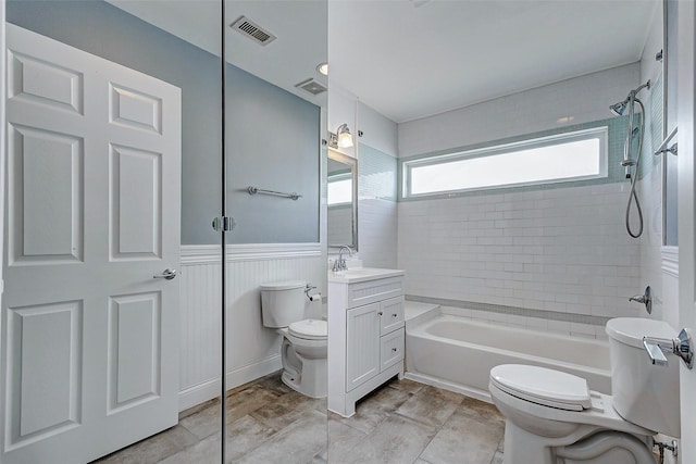 full bathroom with toilet, bathing tub / shower combination, wainscoting, and vanity