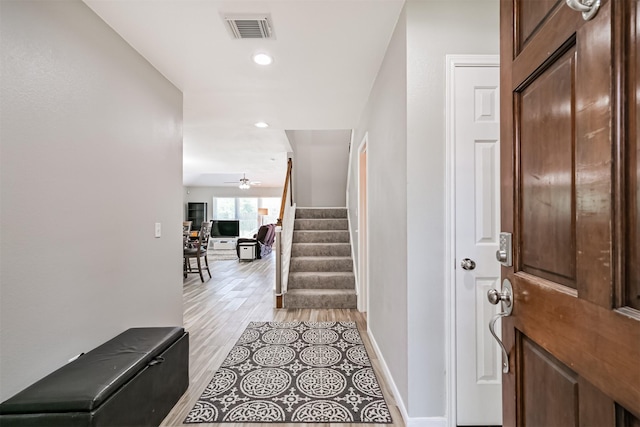 foyer featuring stairs, light wood finished floors, ceiling fan, baseboards, and recessed lighting