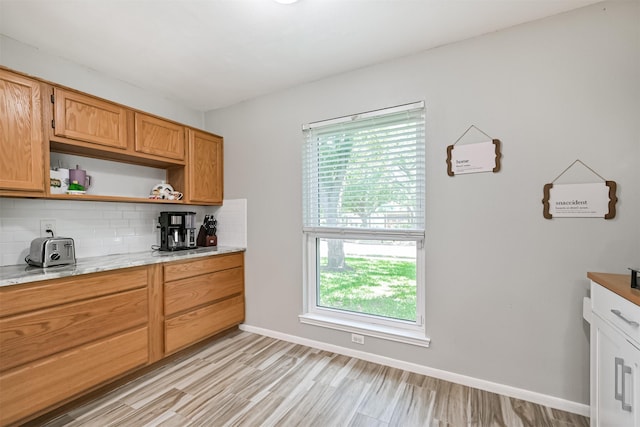 kitchen with open shelves, plenty of natural light, backsplash, and light wood finished floors