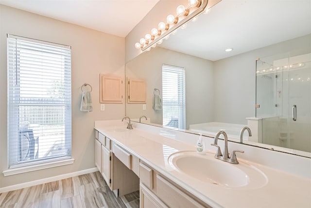 bathroom with a bath, baseboards, double vanity, and a shower stall