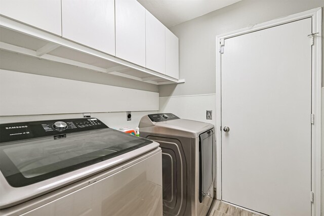 washroom with washer and clothes dryer and cabinet space