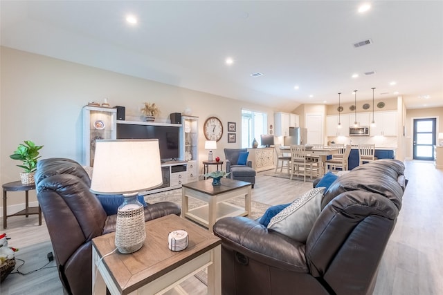 living room with light wood-style flooring and recessed lighting