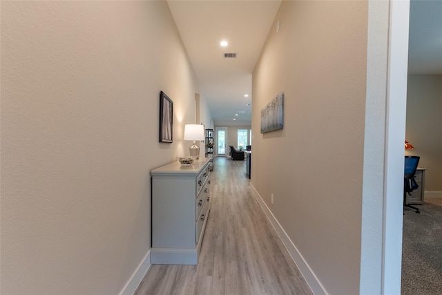 hall with light wood-style flooring, baseboards, and recessed lighting