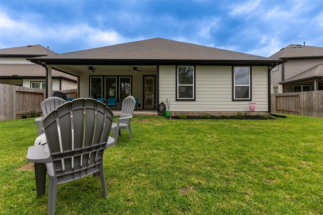 rear view of property with a ceiling fan, a patio area, and roof with shingles