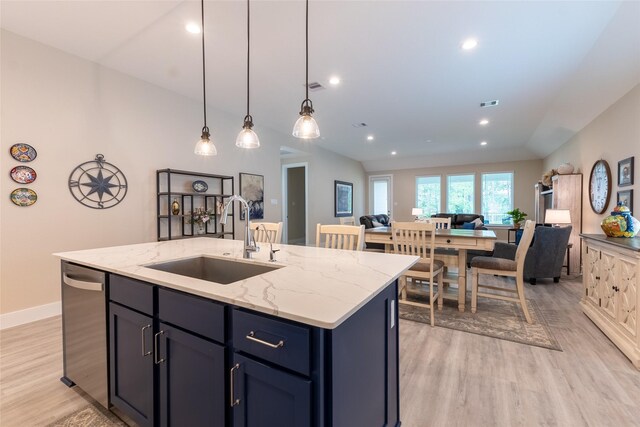 kitchen featuring a sink, dishwasher, light wood-style flooring, open floor plan, and a center island with sink