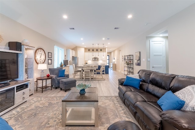 living area with light wood-style floors and recessed lighting