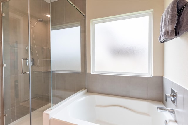 full bathroom with plenty of natural light, a stall shower, and a garden tub