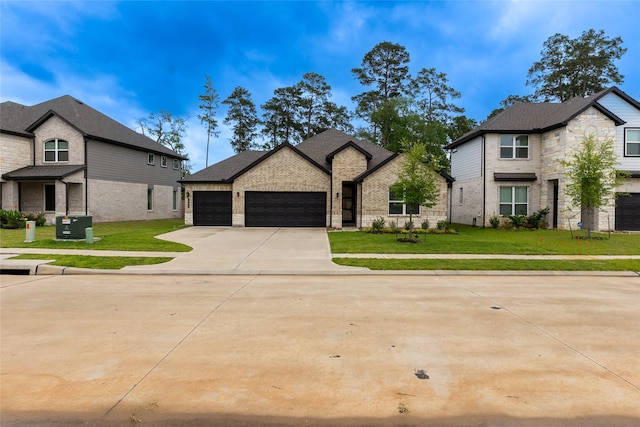 french country style house with a garage, driveway, brick siding, and a front lawn