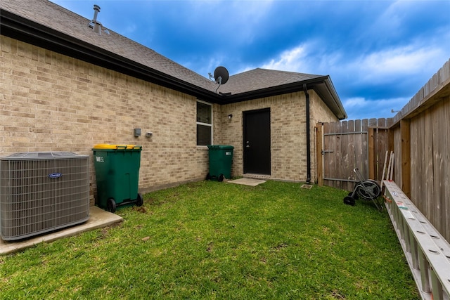 rear view of house with central air condition unit and brick siding
