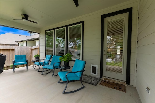 view of patio / terrace with a ceiling fan, fence, and a porch