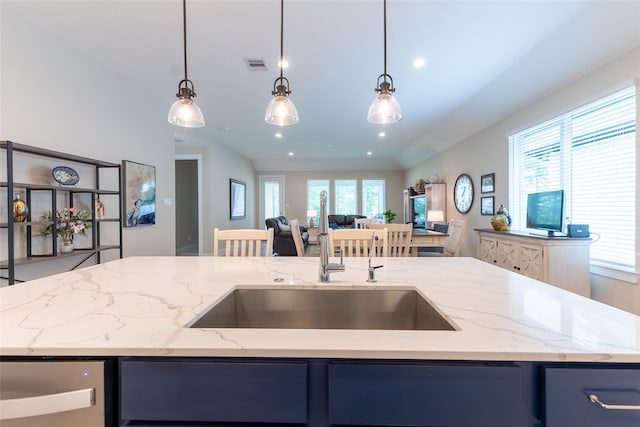kitchen featuring open floor plan, a sink, blue cabinets, a center island with sink, and recessed lighting